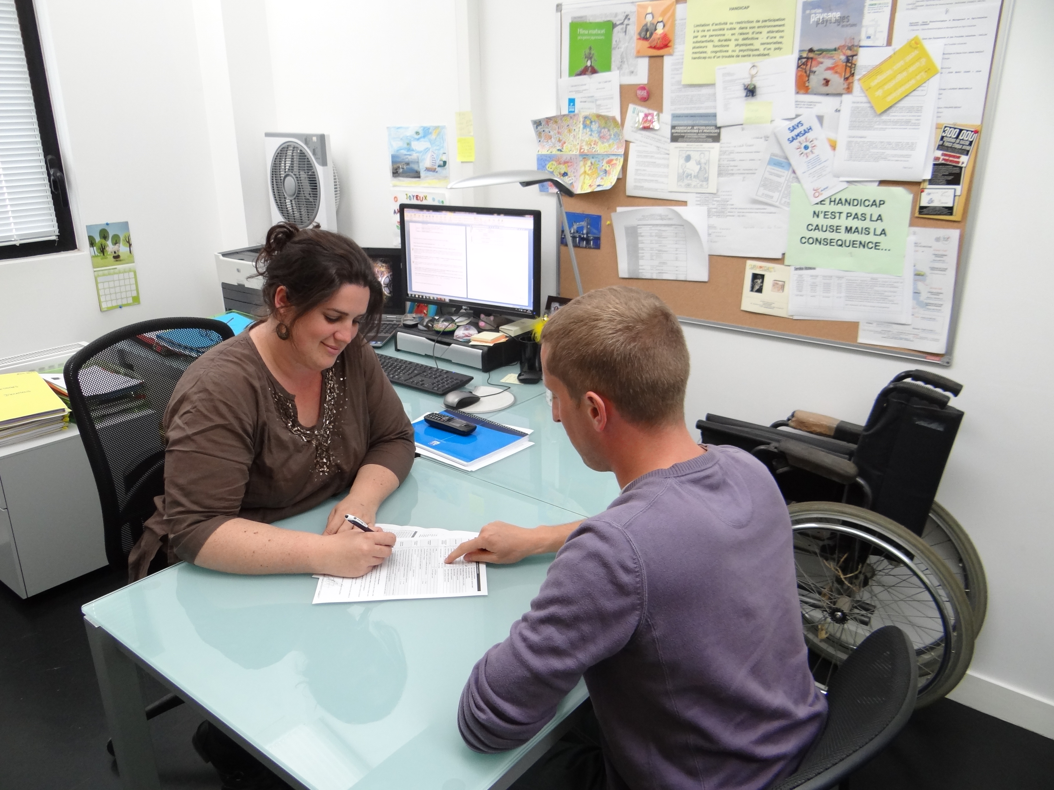 Une femme du Relais Handicap parle avec un étudiant dans un bureau